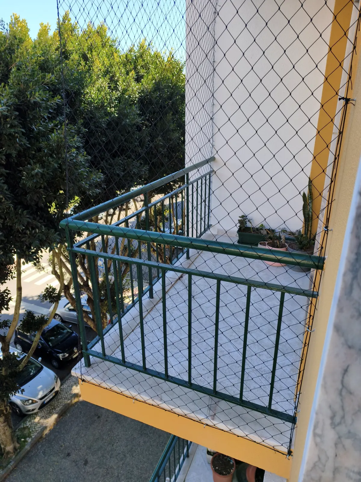 Rede de proteção preta instalada em varanda de apartamento.